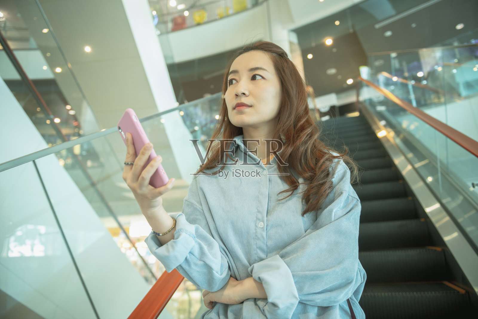 在商场里用智能手机的女人照片摄影图片