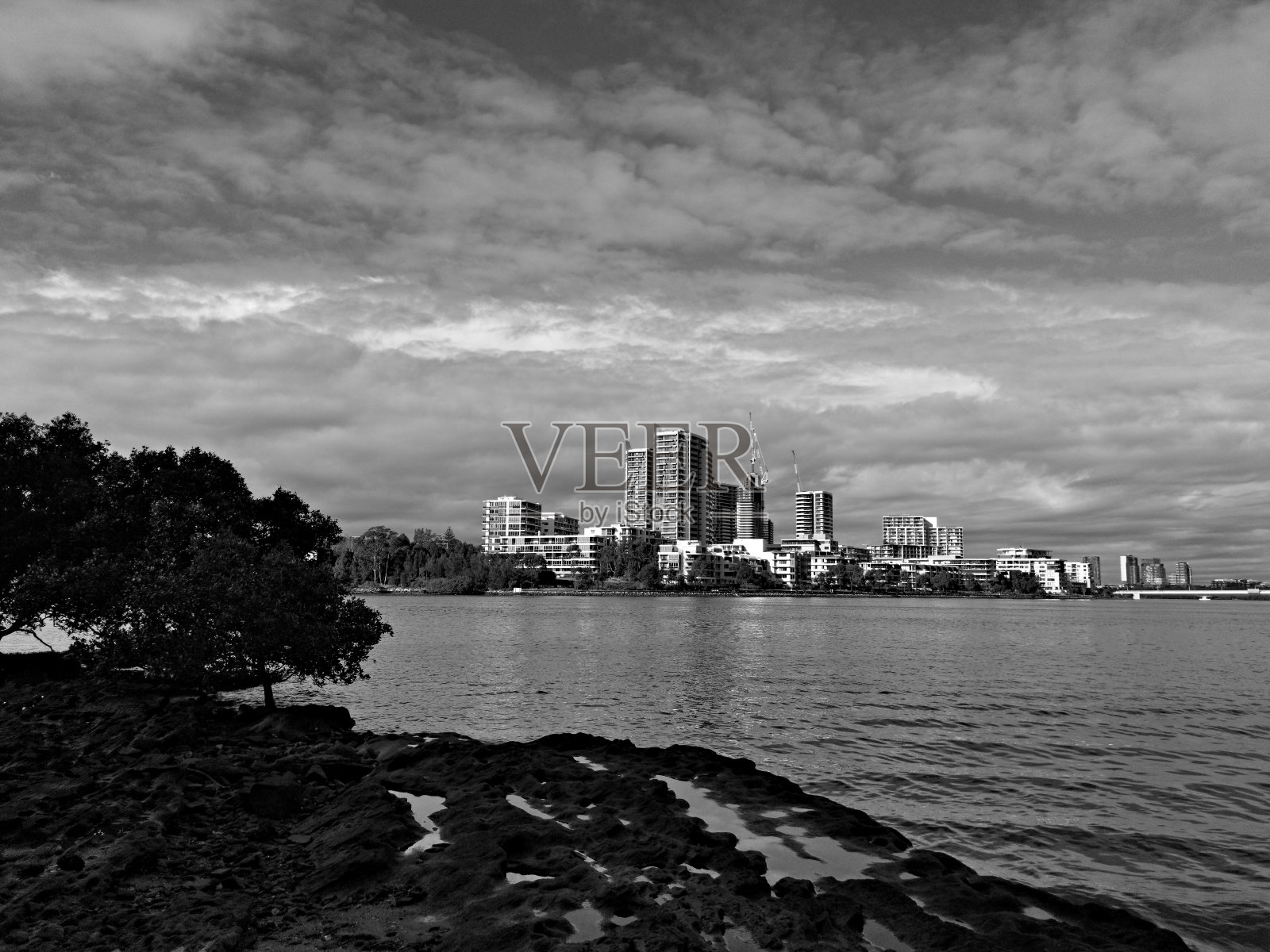 在一个阳光明媚的日子里，河边的高楼大厦有着美丽的黑白景色照片摄影图片