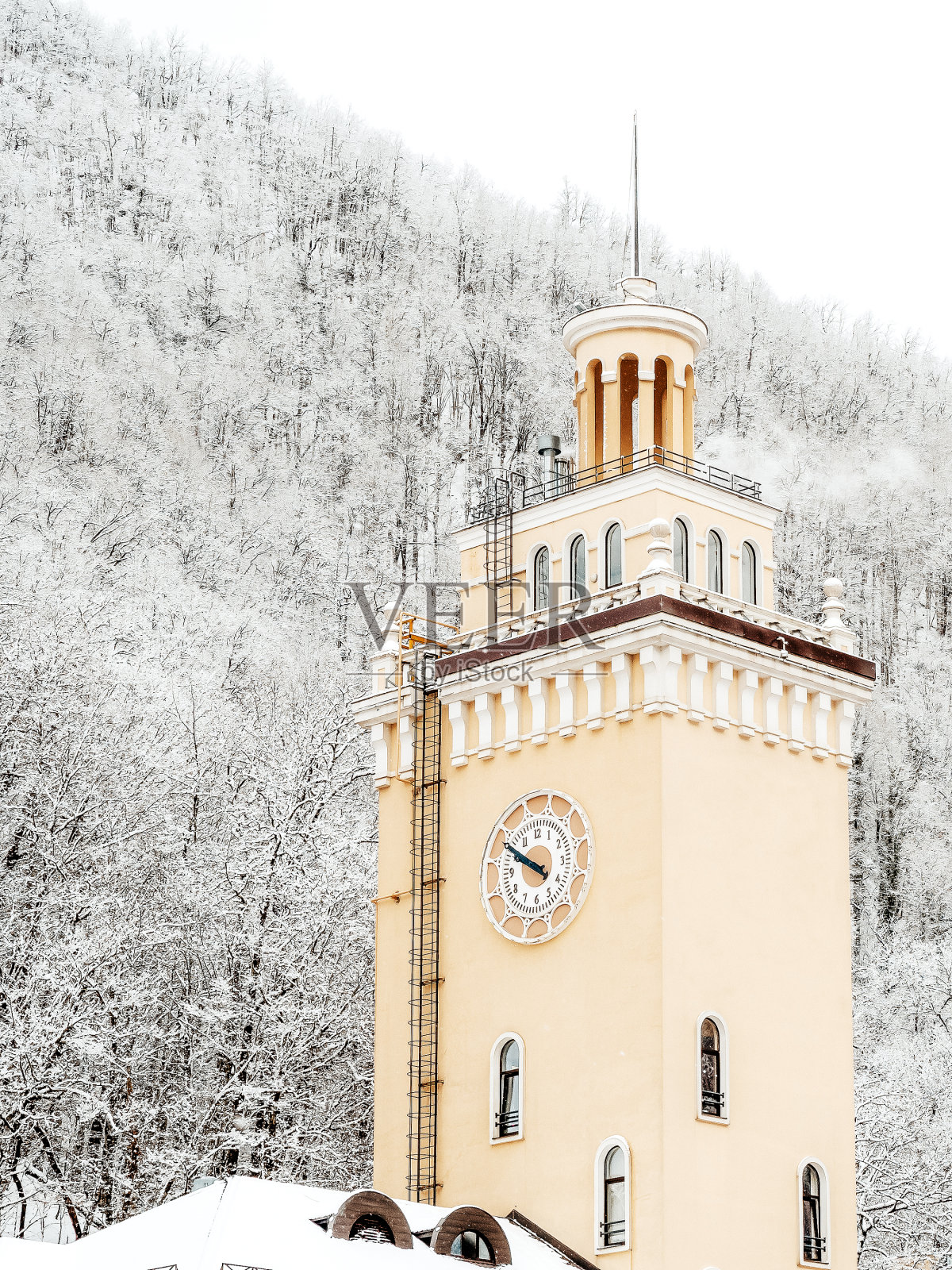 那座钟楼以白雪覆盖的山为背景照片摄影图片