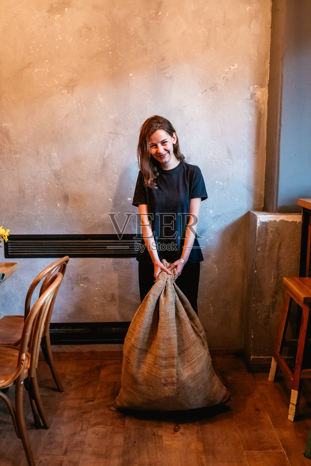 咖啡师拿着装着咖啡的麻袋照片摄影图片