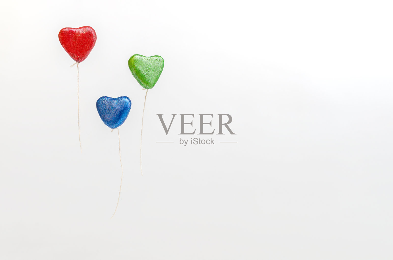 彩色的心形气球，漂浮在白色背景上。照片摄影图片