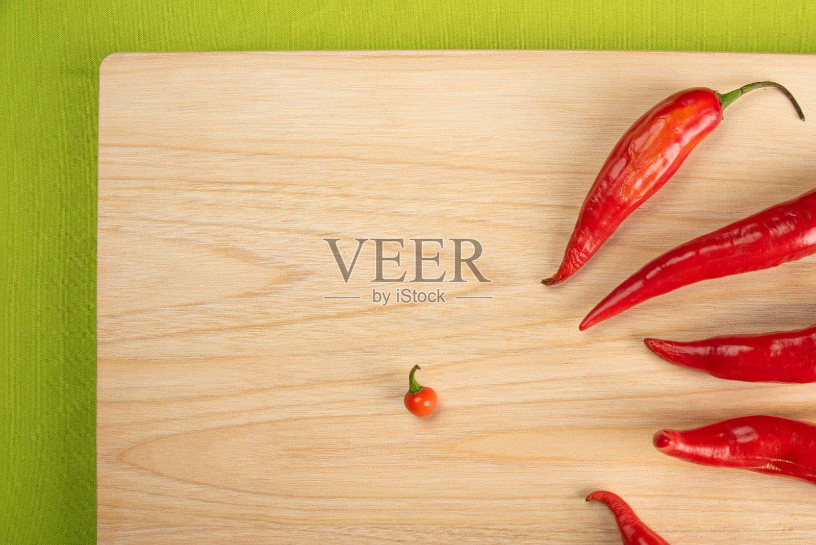 胡椒粉“Dedo de moça”在抛光的木头和绿色桌布上的桌子，俯视图。照片摄影图片