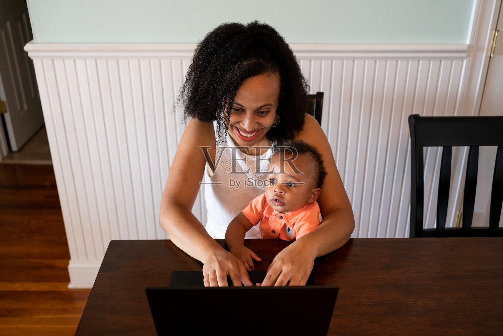 带着孩子在家工作的黑人妇女照片摄影图片