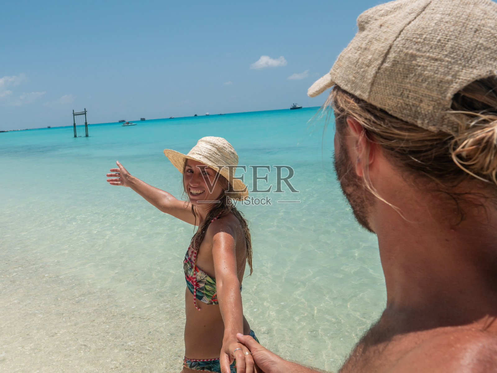一对夫妇牵手在热带美丽的沙滩上荒岛的观点照片摄影图片