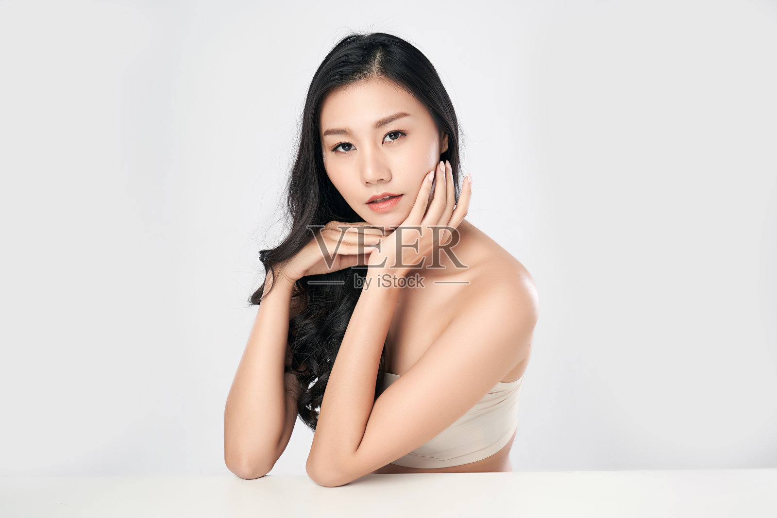 美丽年轻的亚洲女人与清洁新鲜的皮肤，在白色的背景，面部护理，面部治疗。美容、美容和水疗。亚洲女性肖像照片摄影图片