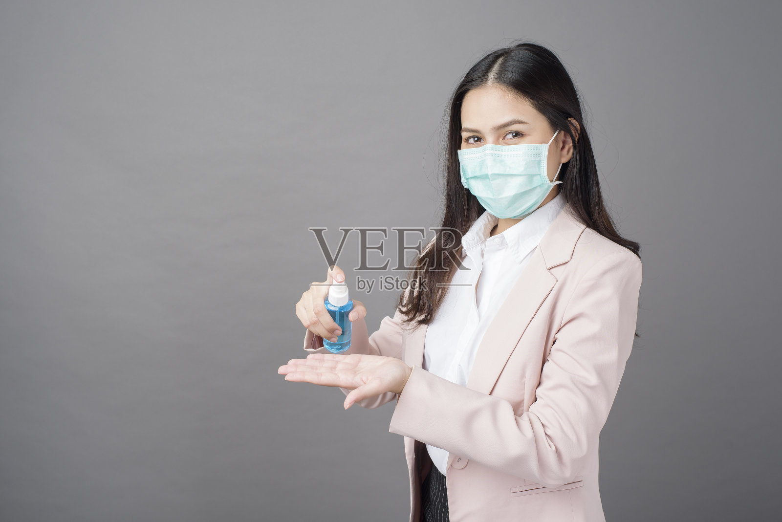 美丽的女商人正在用酒精喷雾剂预防covid- 19照片摄影图片