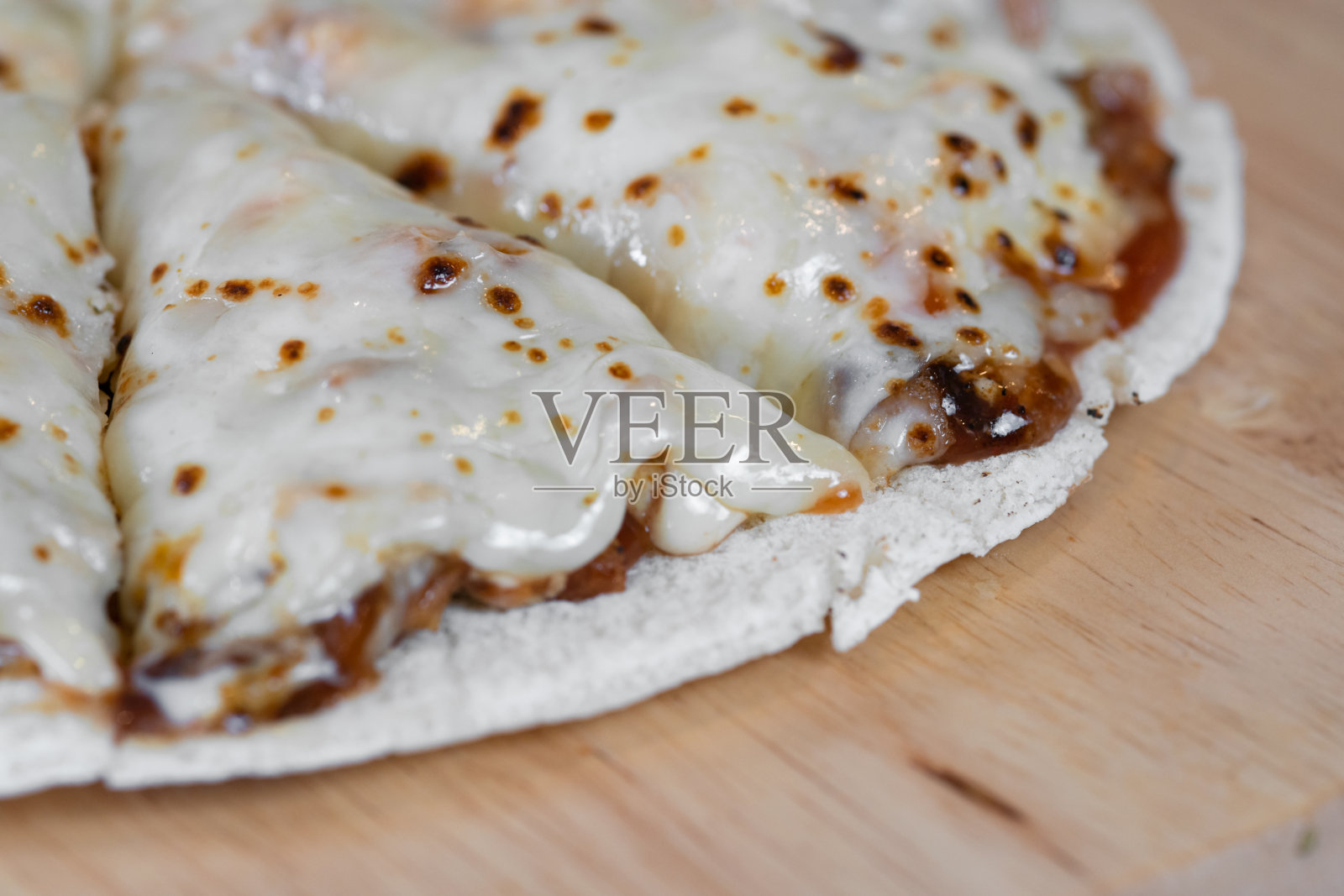 桌子上的木盘子上放着披萨和奶酪照片摄影图片