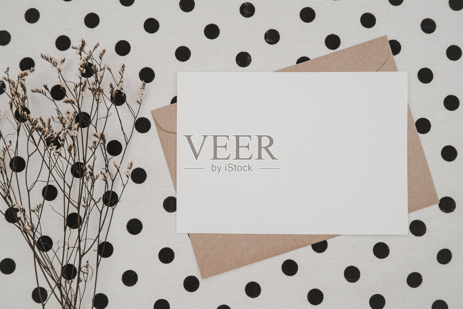 空白白纸，牛皮纸信封与补草干花和纸盒上的白布黑点。模拟水平空白贺卡。俯视图的工艺信封。平的。照片摄影图片