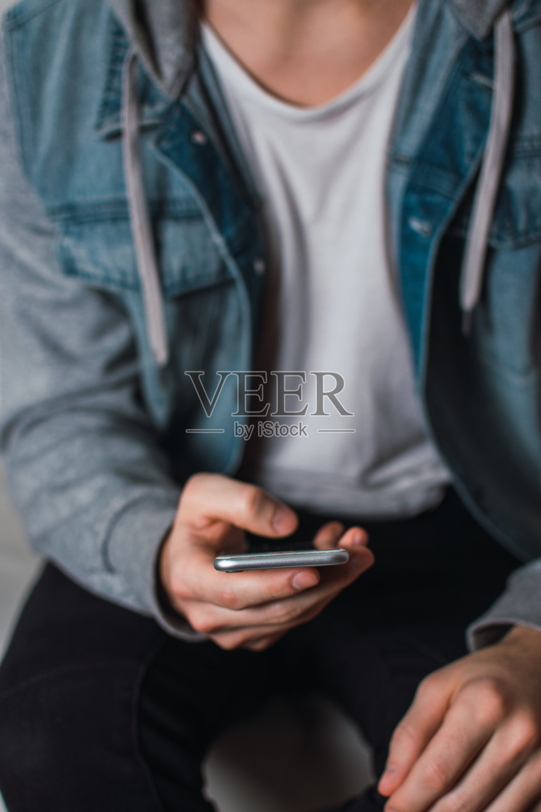 一个年轻人在用他的手机照片摄影图片