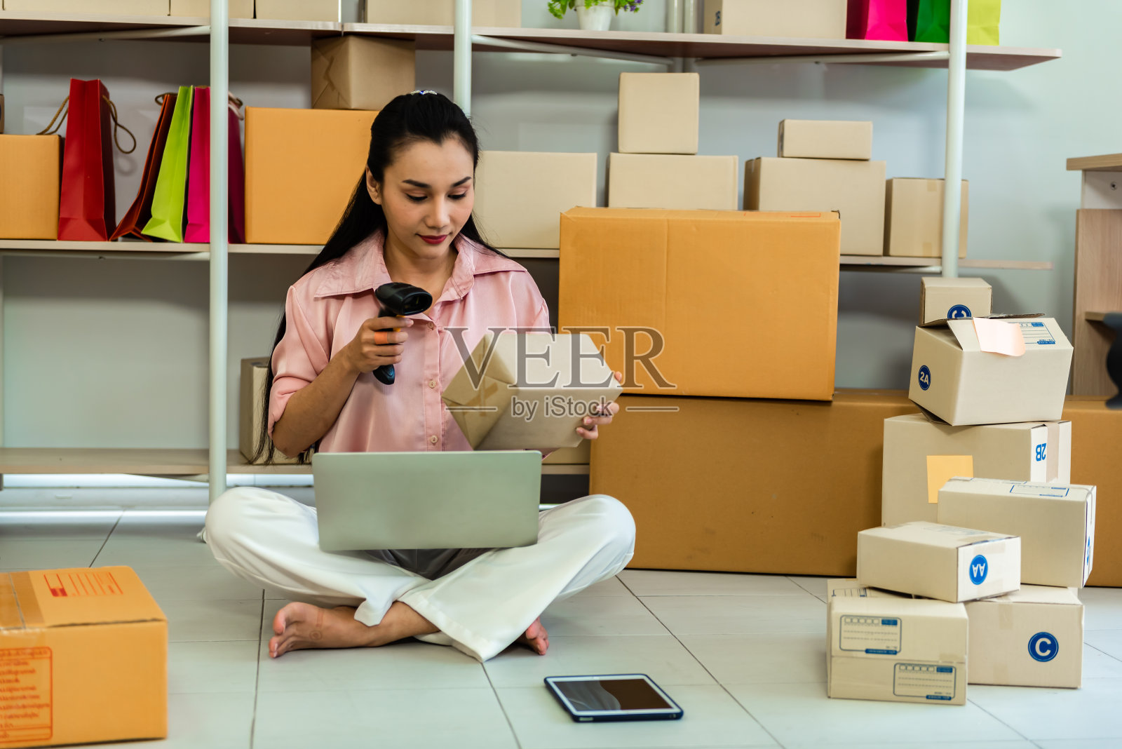 年轻女商人使用无线条形码扫描器扫描包装照片摄影图片