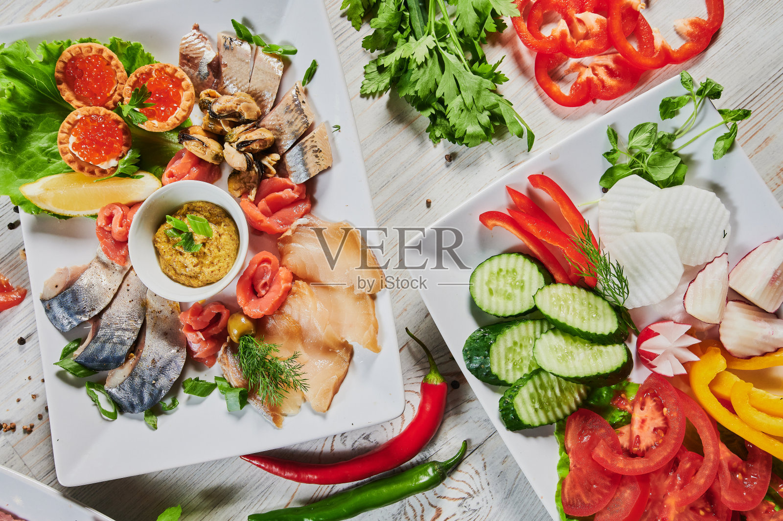 餐桌上有烤肉，烤新土豆，蔬菜，沙拉，酱汁，小吃和柠檬水，俯视图。照片摄影图片