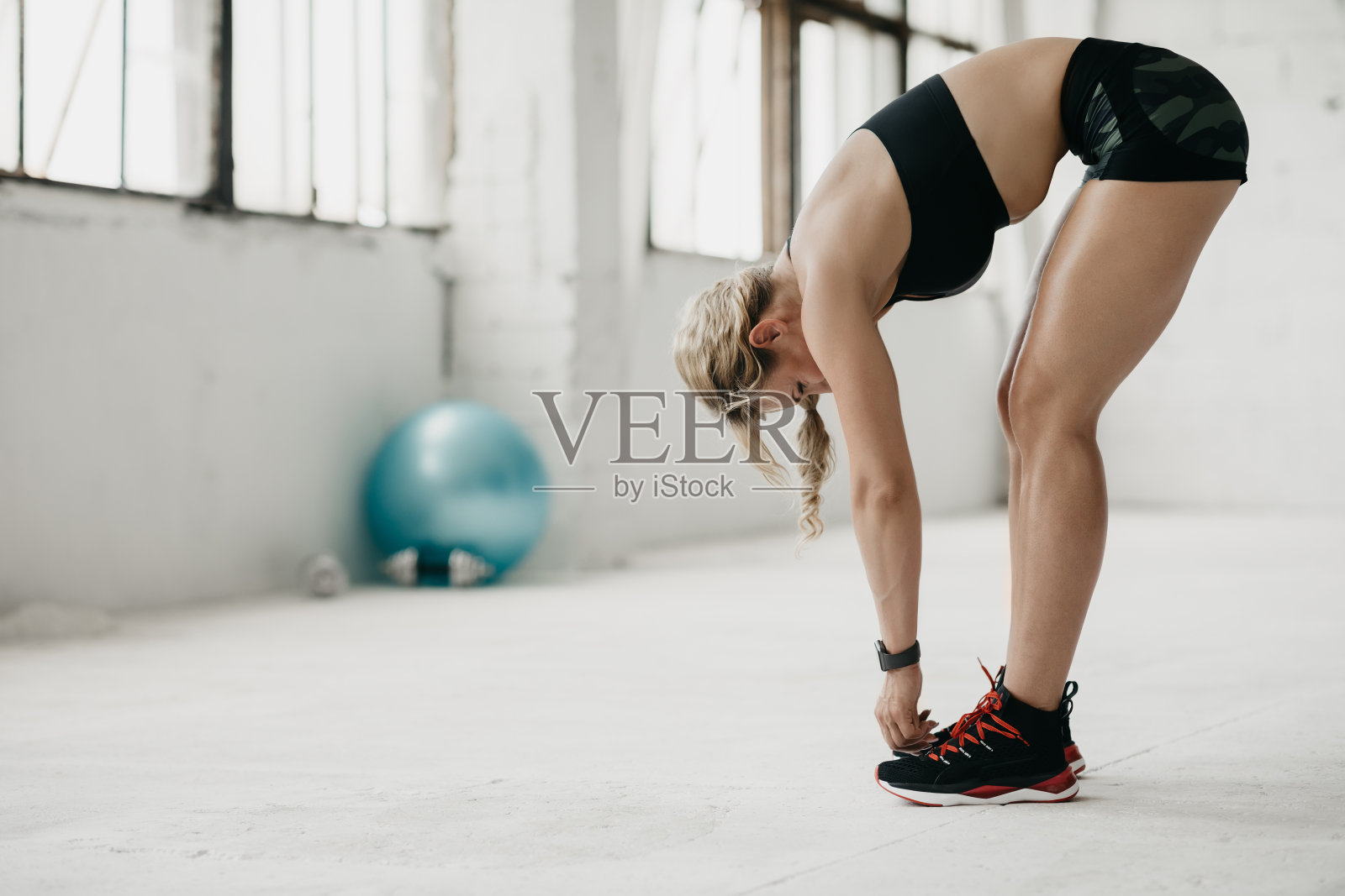 肌肉发达的女人穿着运动服和健身追踪器在健身房工作照片摄影图片