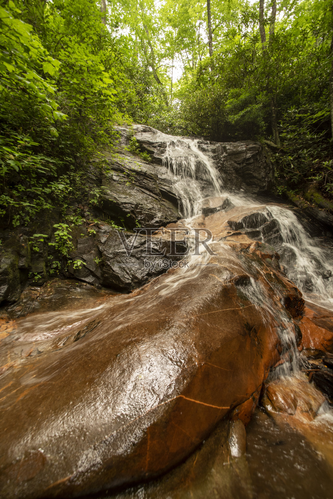 宽角度的特写与长时间暴露的巨石在原木空心瀑布的底部照片摄影图片