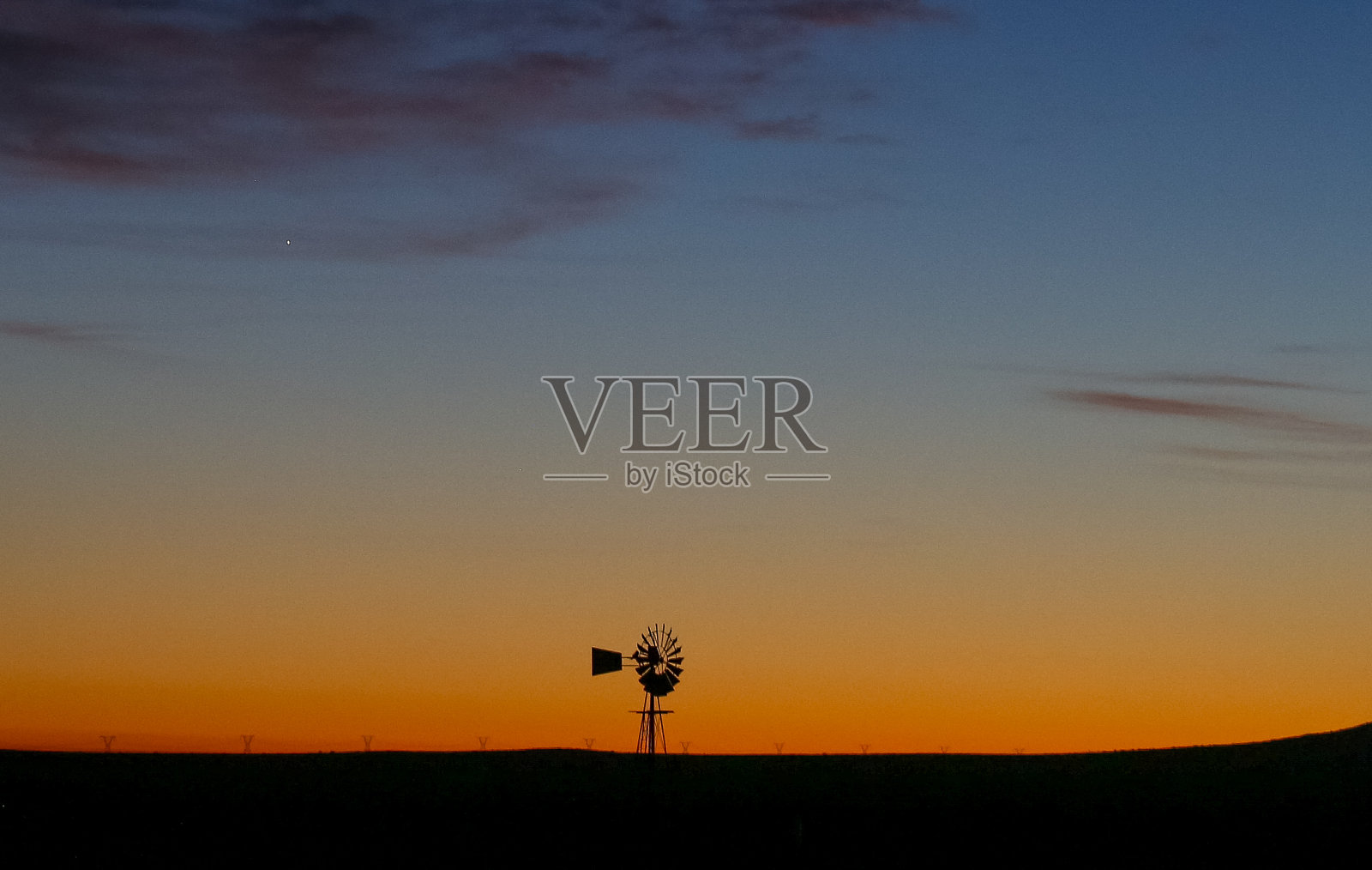 日出与风的轮廓在前景。照片摄影图片