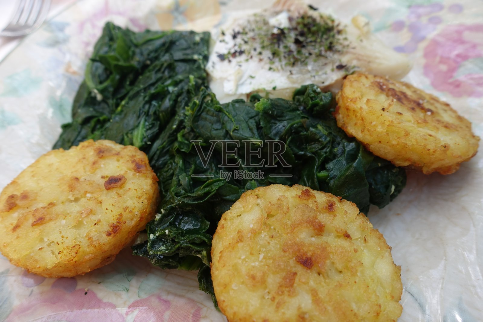 用芳香植物烹制的鳕鱼、洋葱、土豆煎饼和菠菜照片摄影图片