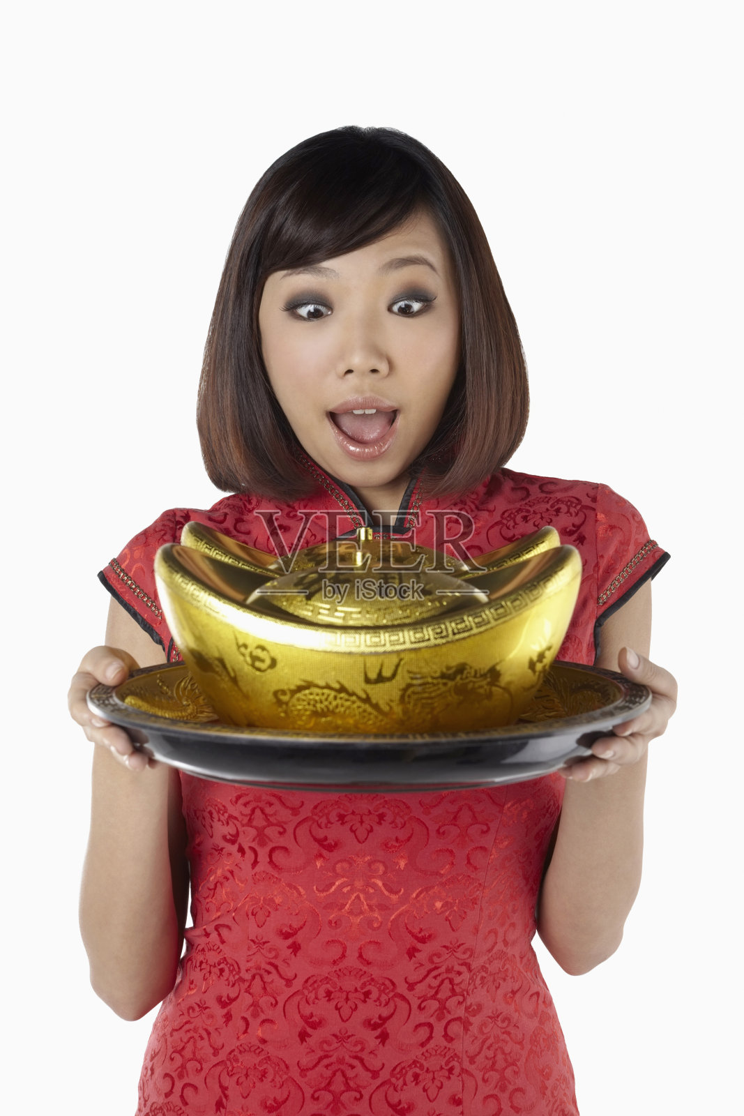 身着旗袍的女子，托着金锭照片摄影图片