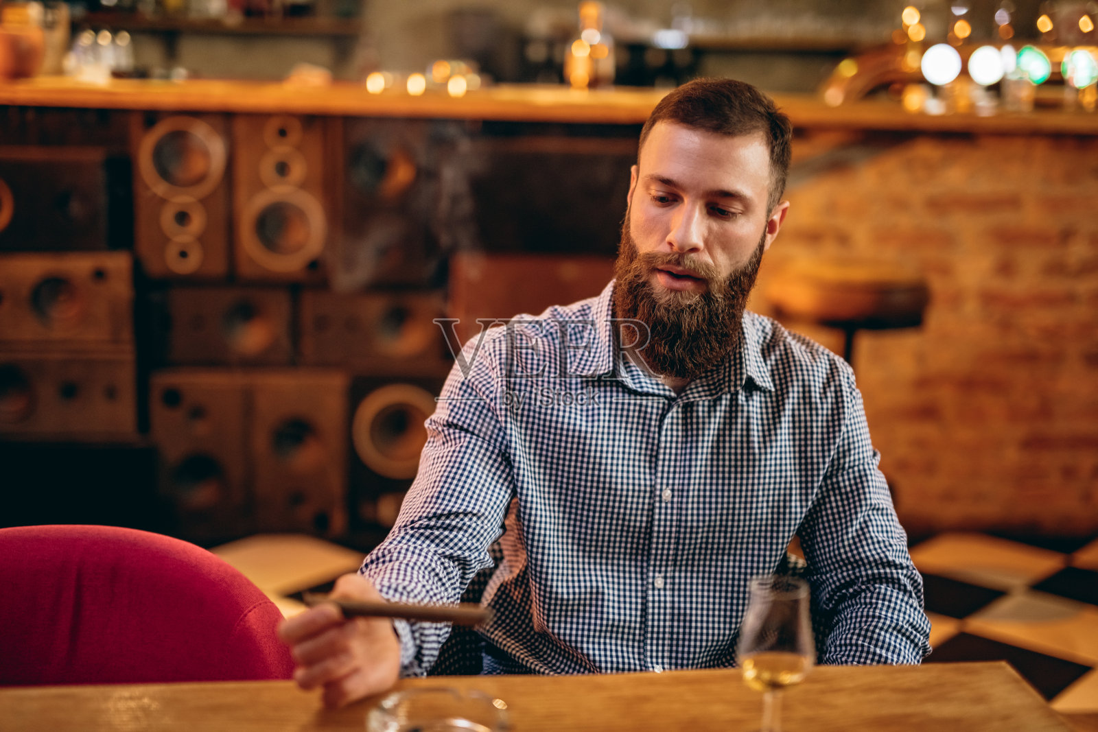 蓄着胡须的帅哥，拿着一杯威士忌照片摄影图片