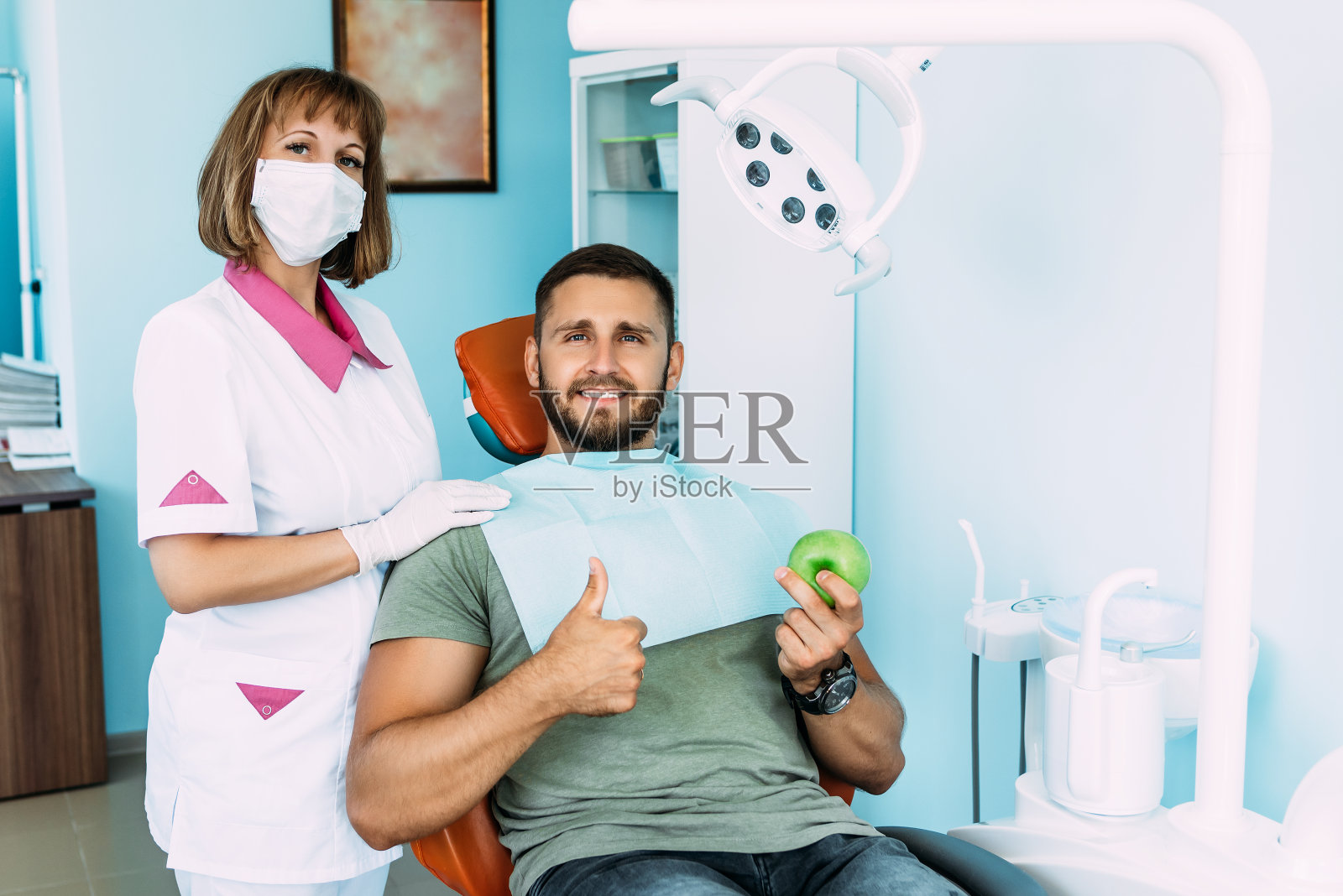 给病人做牙科检查。牙医检查病人的牙齿。牙医。牙科保健。一个人在牙医那里治疗他的牙齿。声音的牙齿。预防龋齿。本空间照片摄影图片