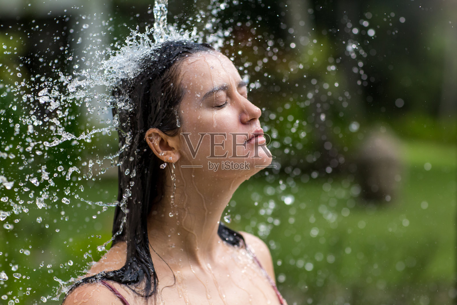 年轻苗条的女人在室外淋浴下洗澡。夏天的生活方式照片摄影图片