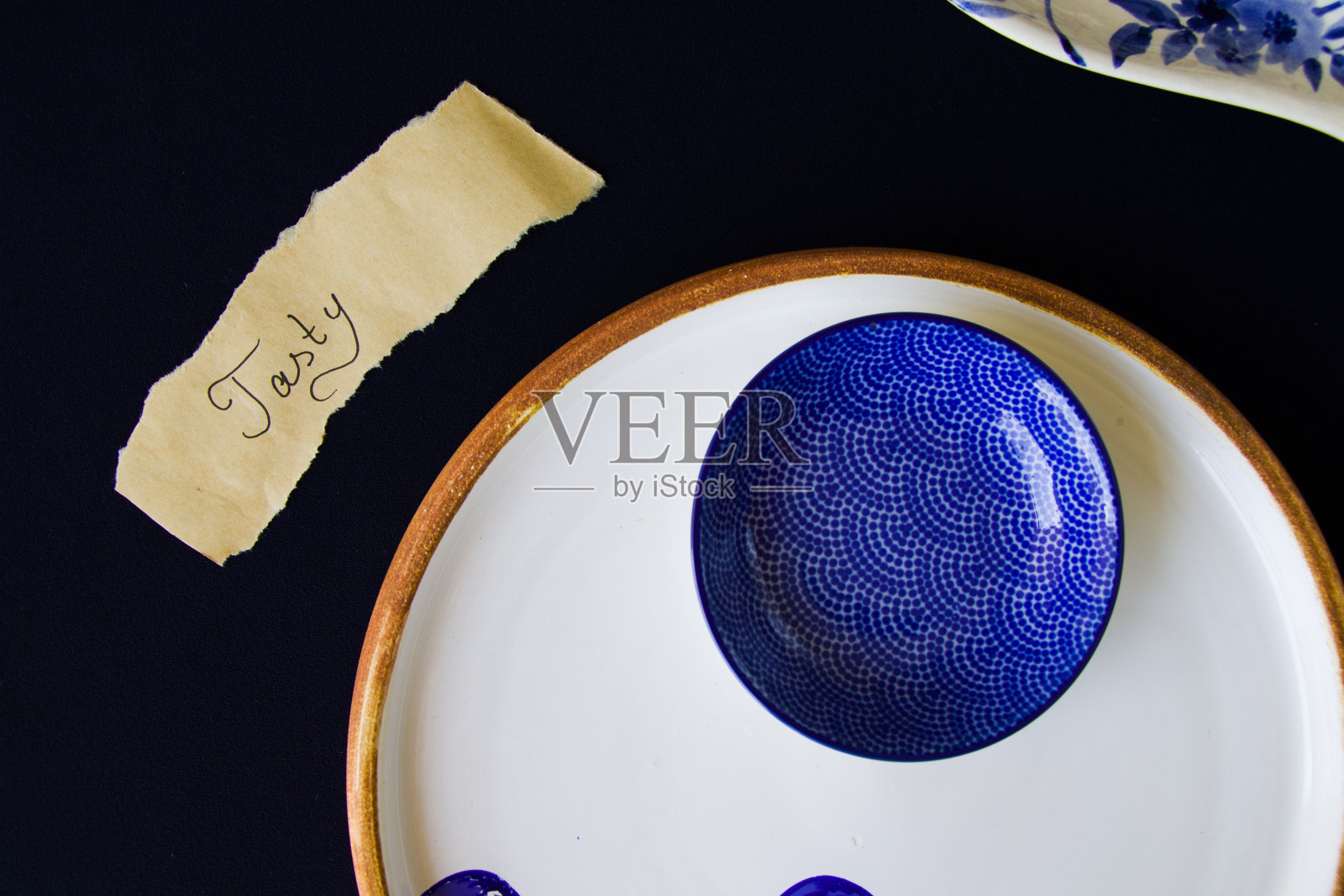 空蓝色餐具，纸和美味的文字，碗和盘子在桌子上照片摄影图片