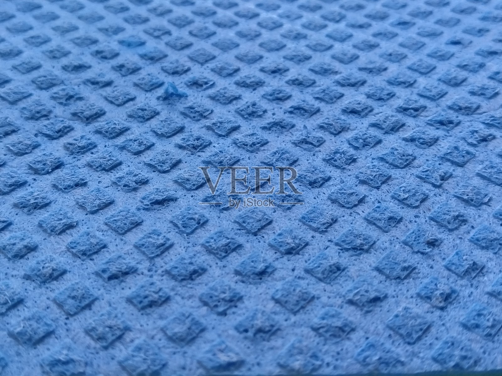 蓝色的洗碗海绵，特写。抽象的蓝色背景。软焦点照片摄影图片