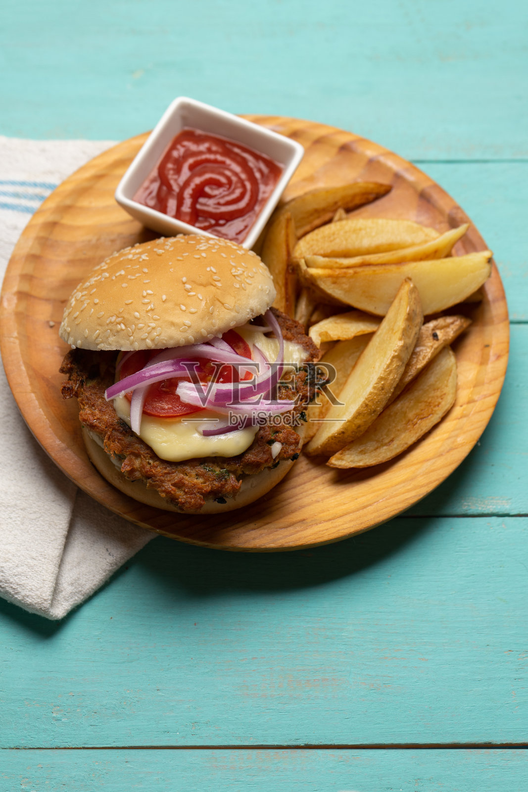 金枪鱼汉堡和土豆薯条在绿松石的背景照片摄影图片