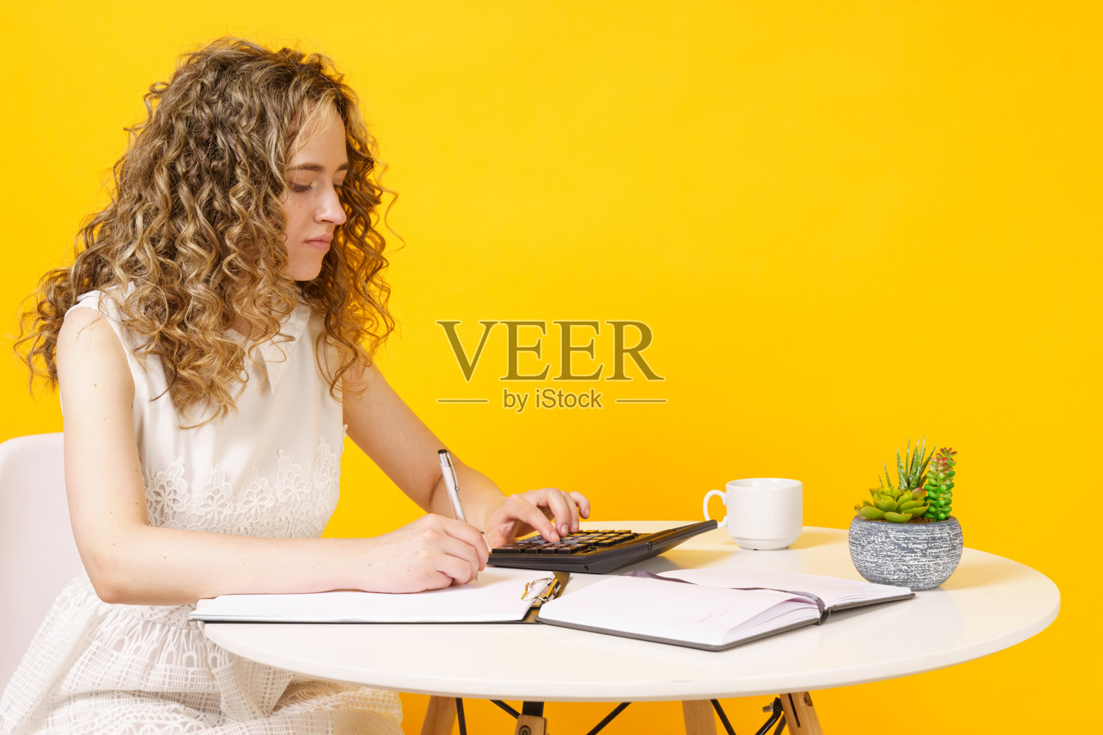 一个年轻的女人坐在桌子旁，处理文件，思考，研究。教育。业务。照片摄影图片