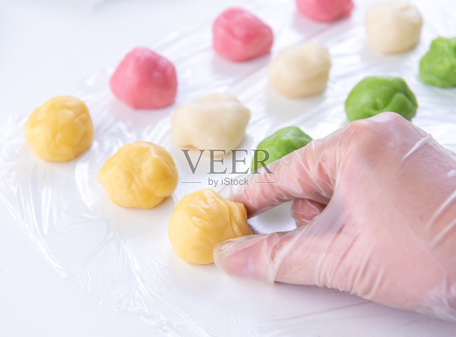 年轻女子正在制作彩色雪皮月饼，配方甜雪月饼，传统美味的甜点中秋节，近距离，生活方式。照片摄影图片