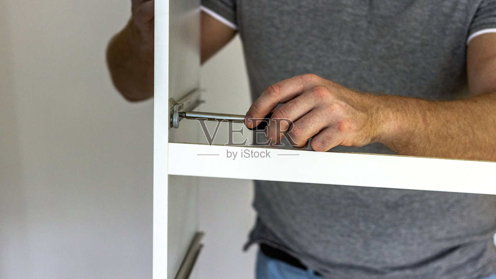 男人在家里安装室内家具。照片摄影图片