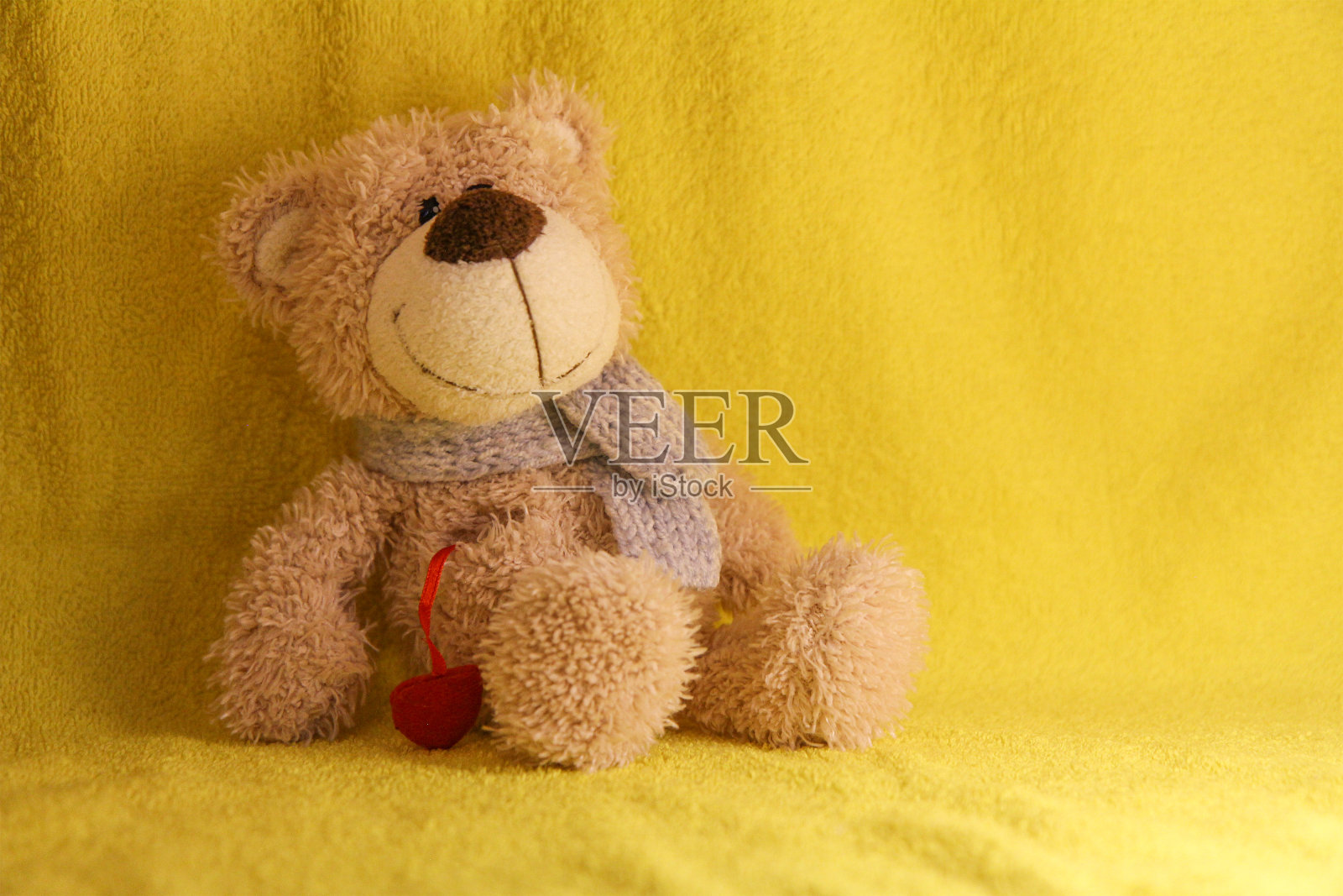 黄色背景的儿童玩具熊。照片摄影图片