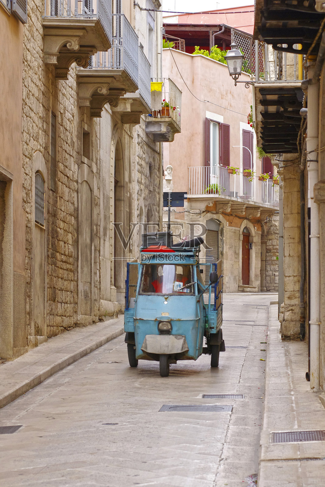 三轮轻型商用车在狭窄的老城区街道上照片摄影图片