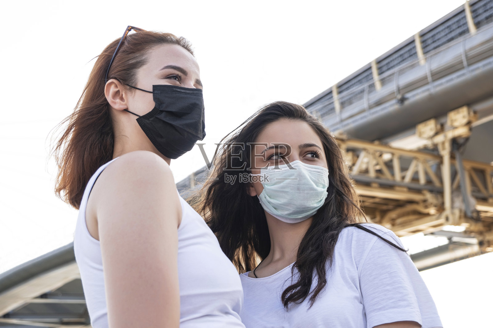2019冠状病毒病大流行的新冠病毒，城市街道上的年轻女孩戴着口罩，以防止2019冠状病毒病的传播照片摄影图片