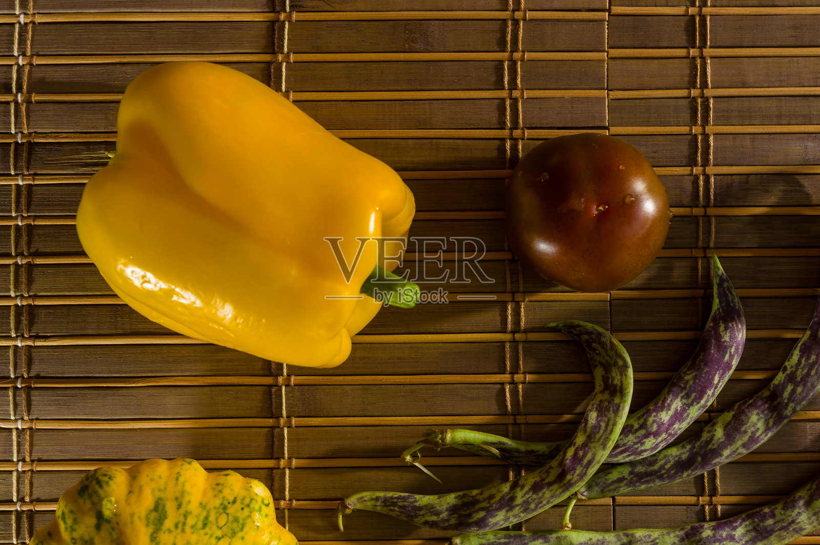 秋季静物-小斑点南瓜，芦笋豆，紫色罗勒，辣椒，黄色和巧克力西红柿在竹席上照片摄影图片