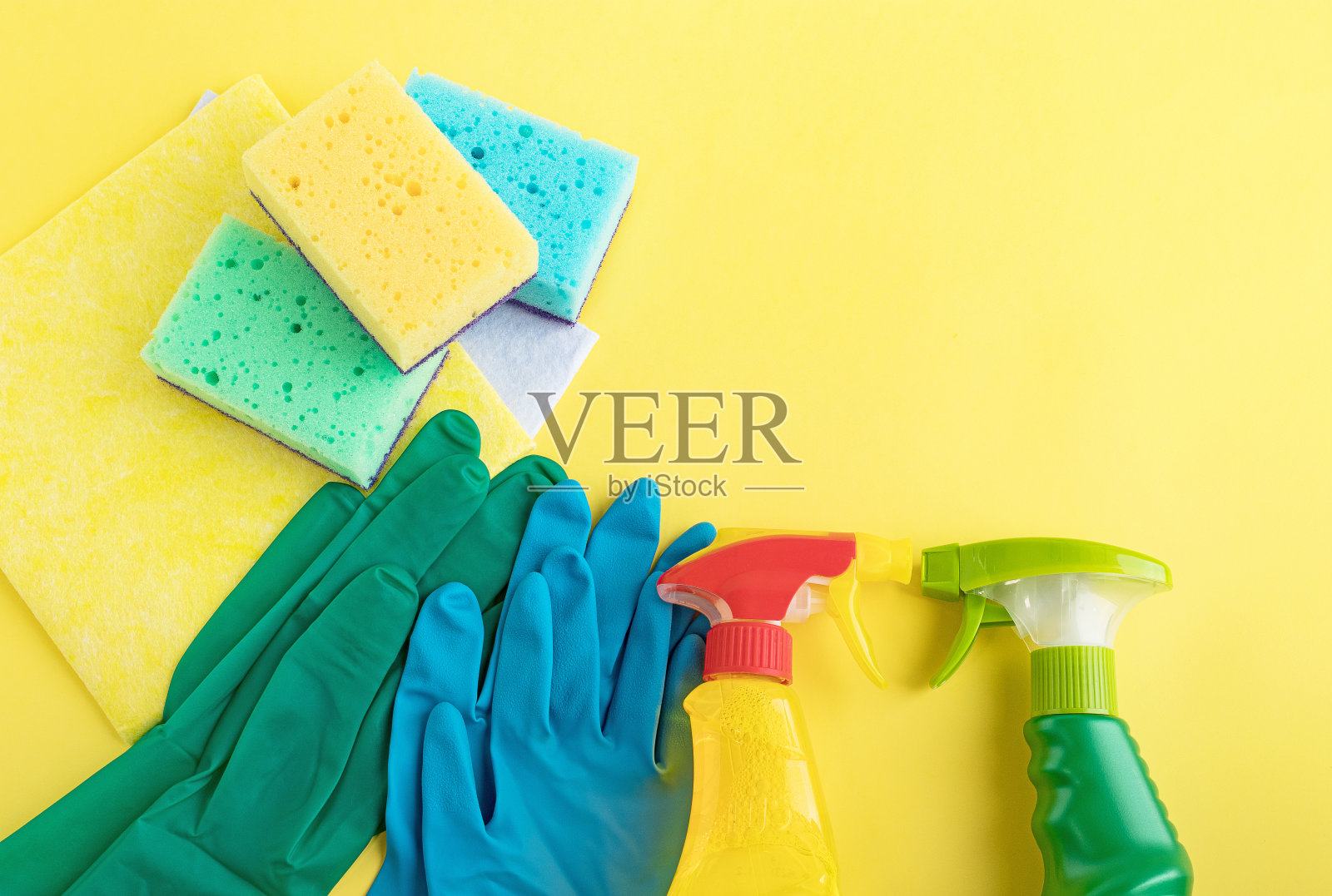 手套，餐巾，海绵，洗涤剂，黄色背景。设置为厨房各种表面清洁，浴室等区域的清洁概念。前视图。平躺照片摄影图片