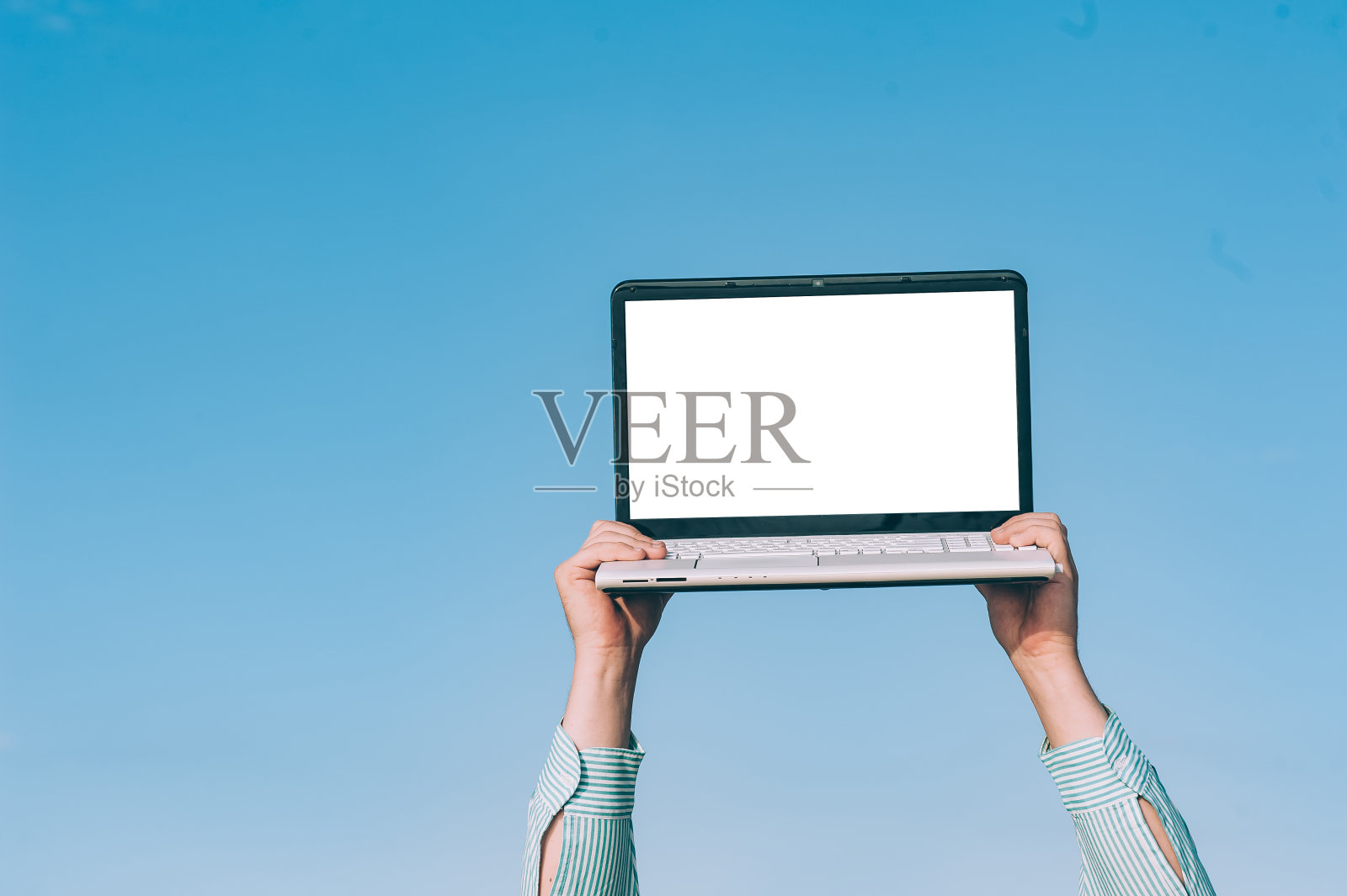 一个人拿着模拟的笔记本电脑，对着天空。照片摄影图片