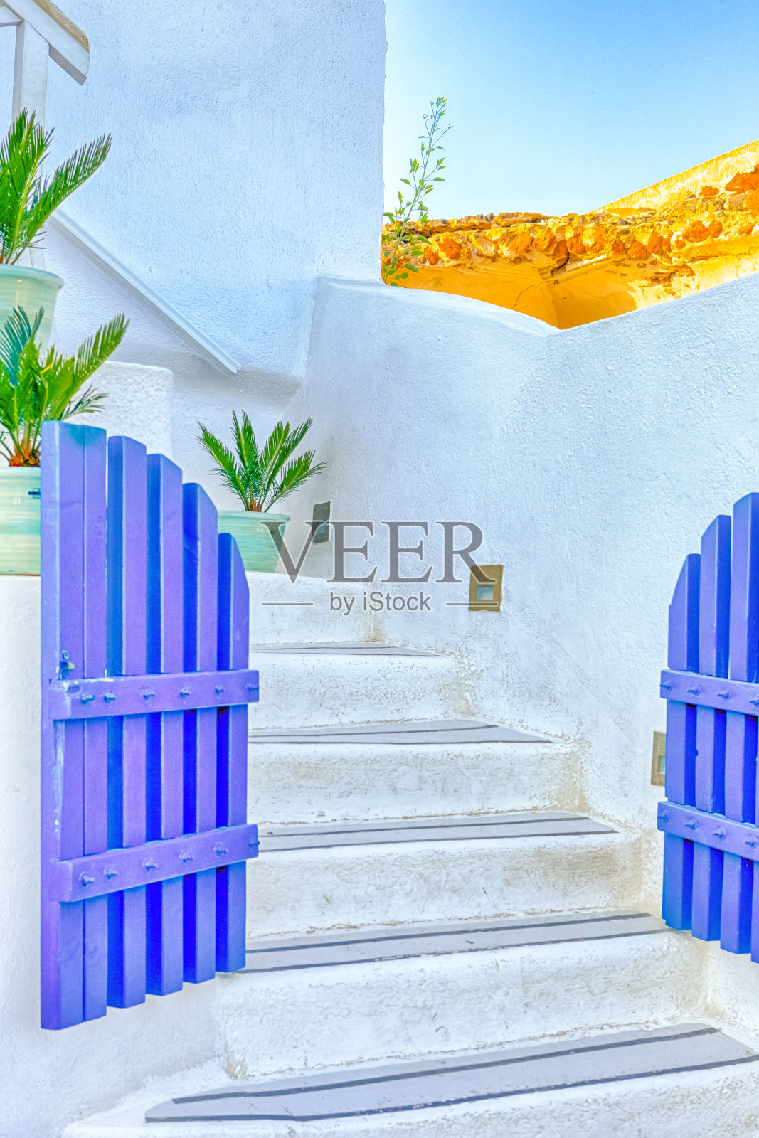 欧洲的目的地。希腊圣托里尼岛伊亚村房屋中的古老蓝门和白色楼梯。垂直的图像组成照片摄影图片