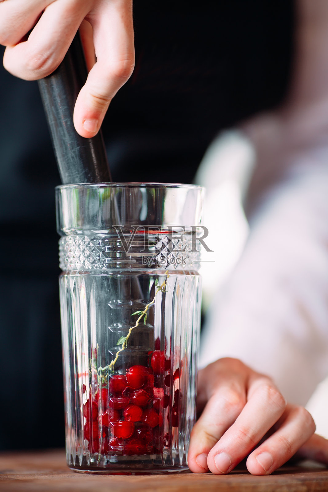 调酒师在餐厅的露台上准备一杯浆果鸡尾酒。照片摄影图片