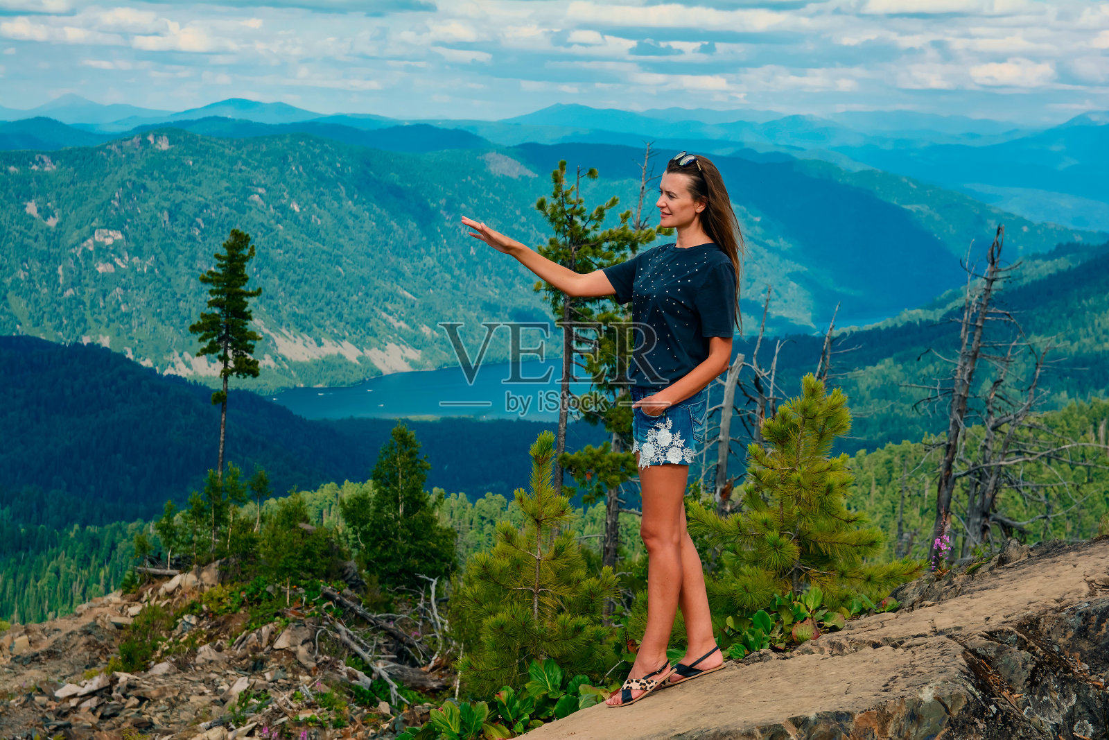 年轻美丽的女孩在一个美丽的山景背景在夏天照片摄影图片