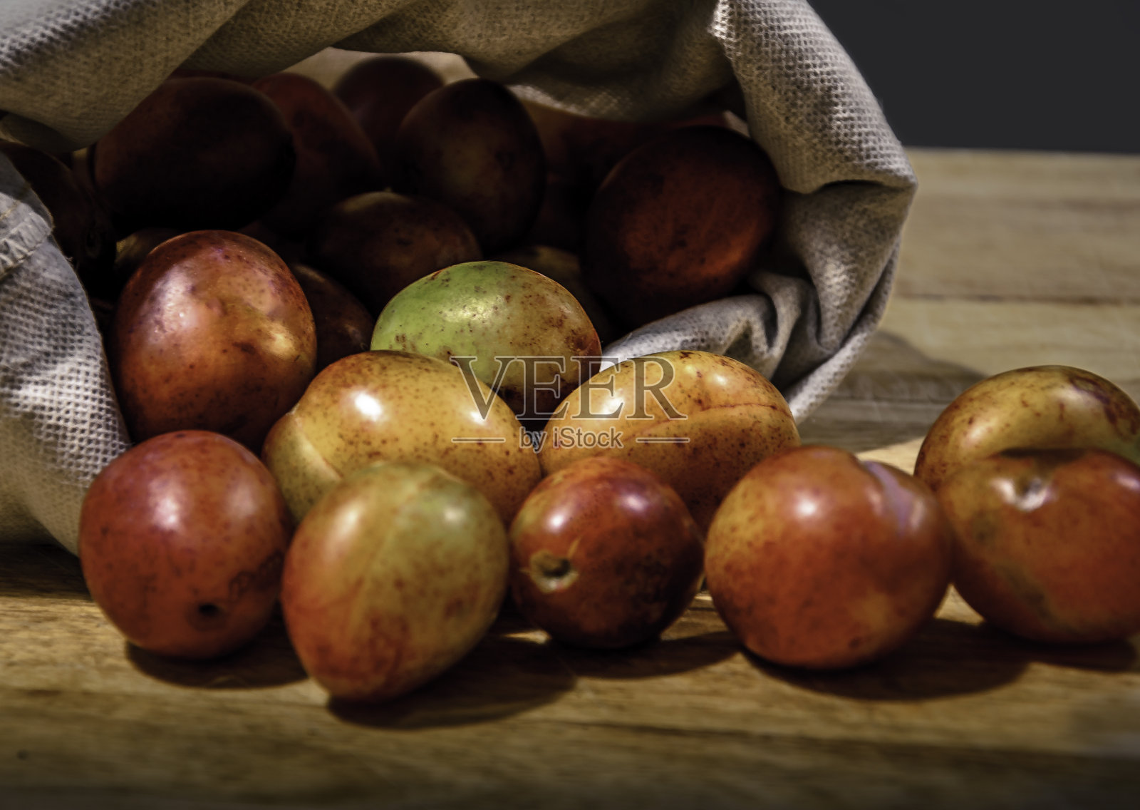 新采摘的李子在粗麻袋照片摄影图片