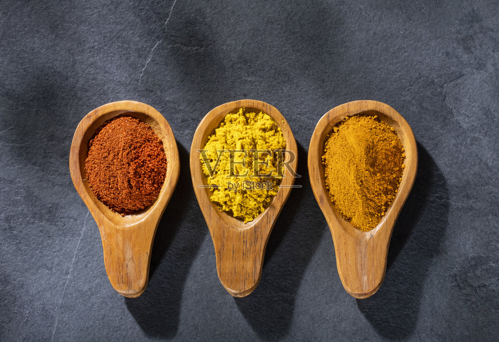 木勺里放咖喱，姜黄和辣椒照片摄影图片