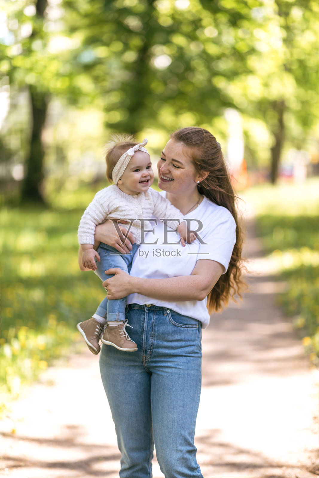 一位年轻的母亲带着她一岁的女儿在一个阳光明媚的日子里散步。如何让自己在做母亲的过程中远离倦怠并获得乐趣照片摄影图片