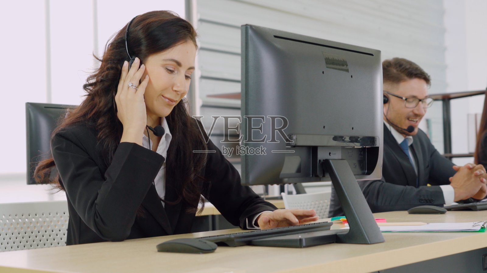 商务人员戴着耳机在办公室工作照片摄影图片