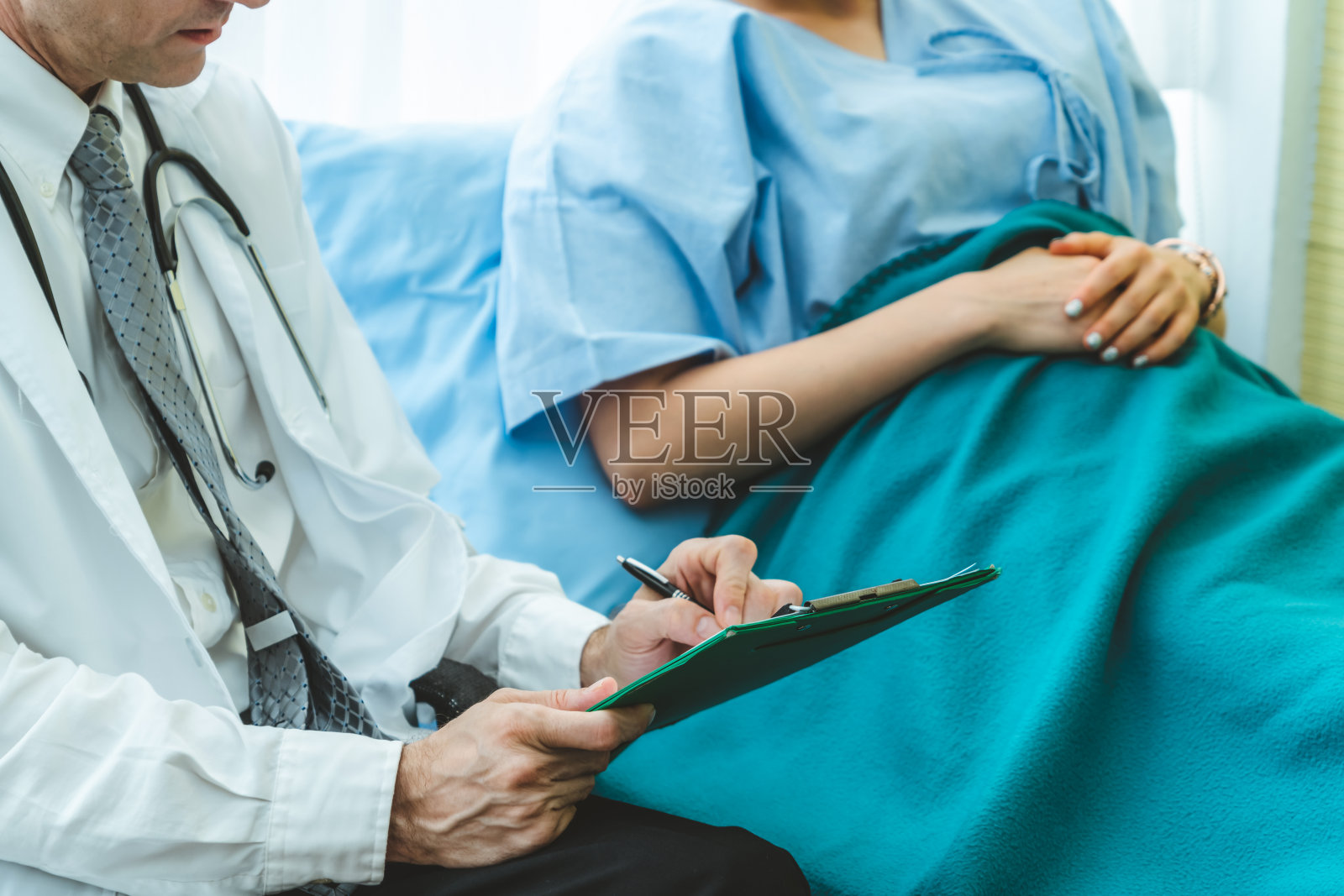 身穿专业制服的医生在医院为病人检查照片摄影图片