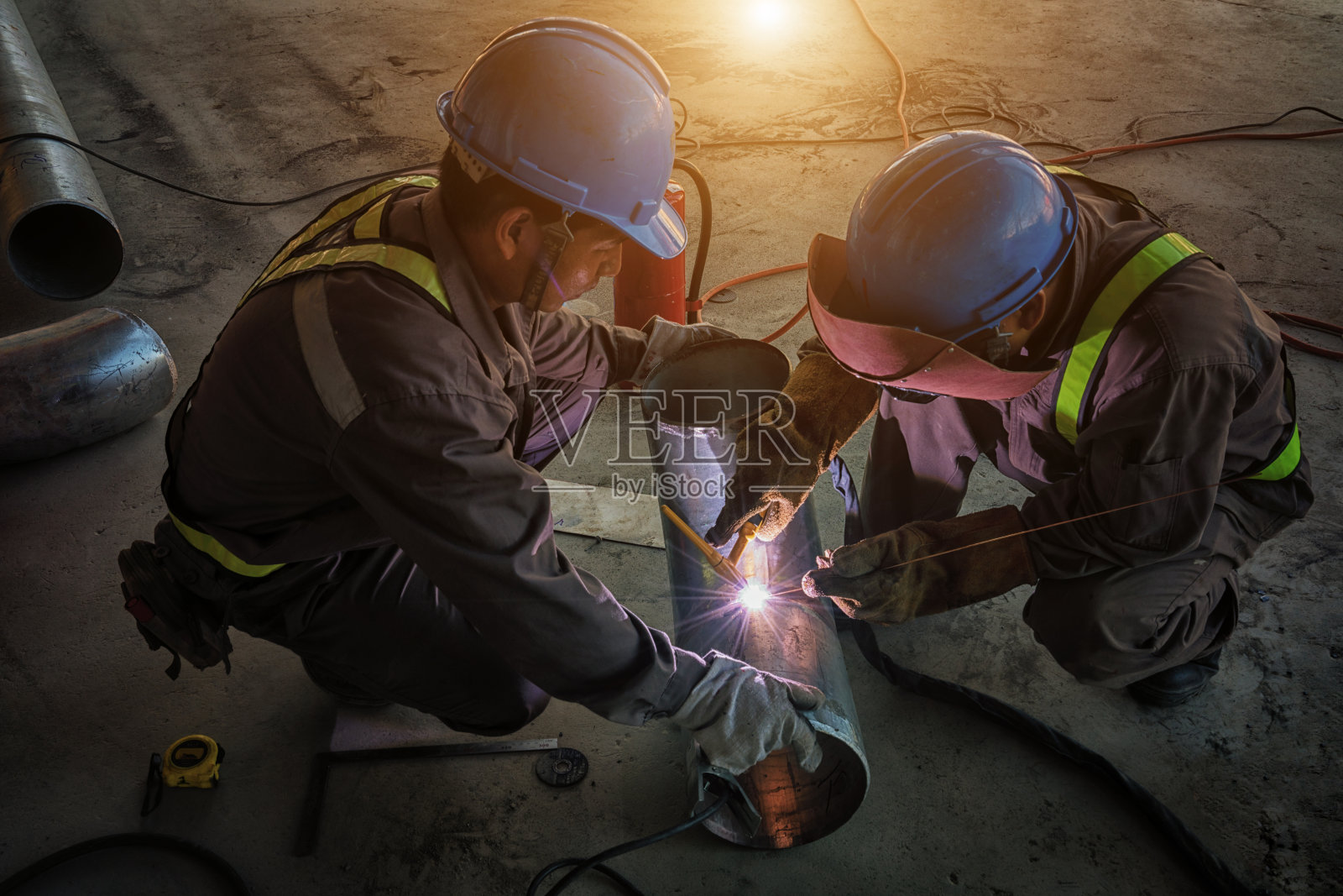 在工厂施工中，技术人员正在焊接连接主洒水喷头的接头弯头管照片摄影图片