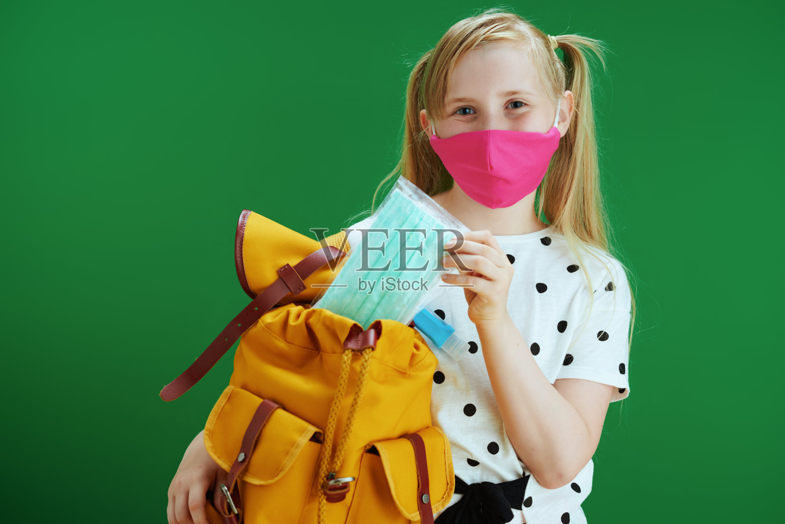 儿童将额外的医用口罩放入背包照片摄影图片