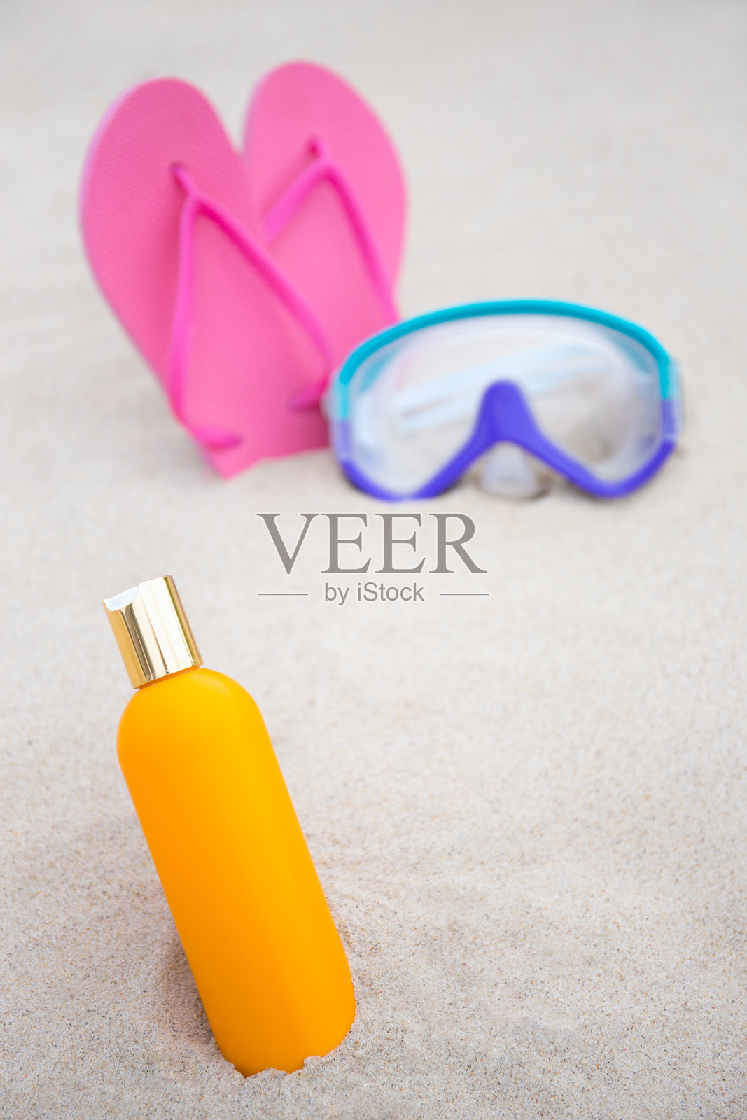 护肤理念-近距离晒黑瓶，潜水面罩和人字拖在沙滩上照片摄影图片