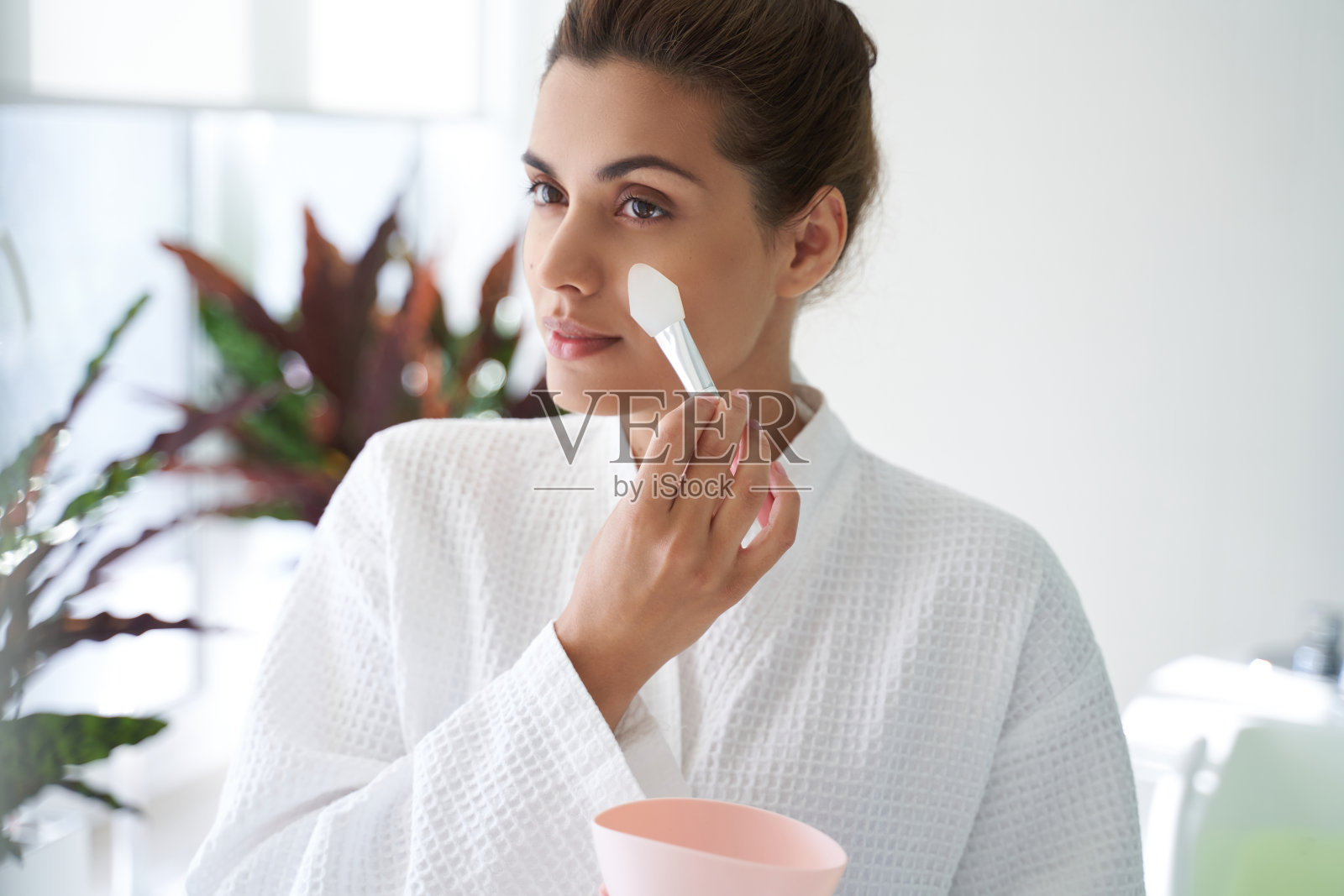 女士用专用工具小心地将面膜敷在脸上照片摄影图片