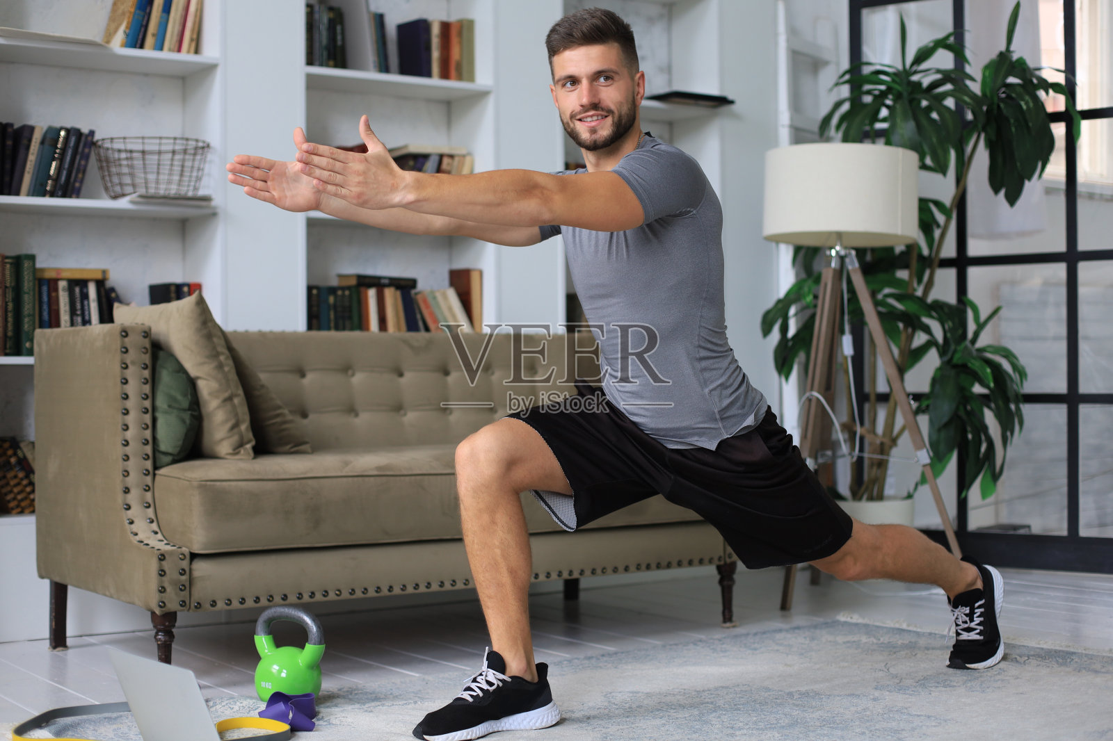 帅哥在家做运动。健康生活理念。照片摄影图片