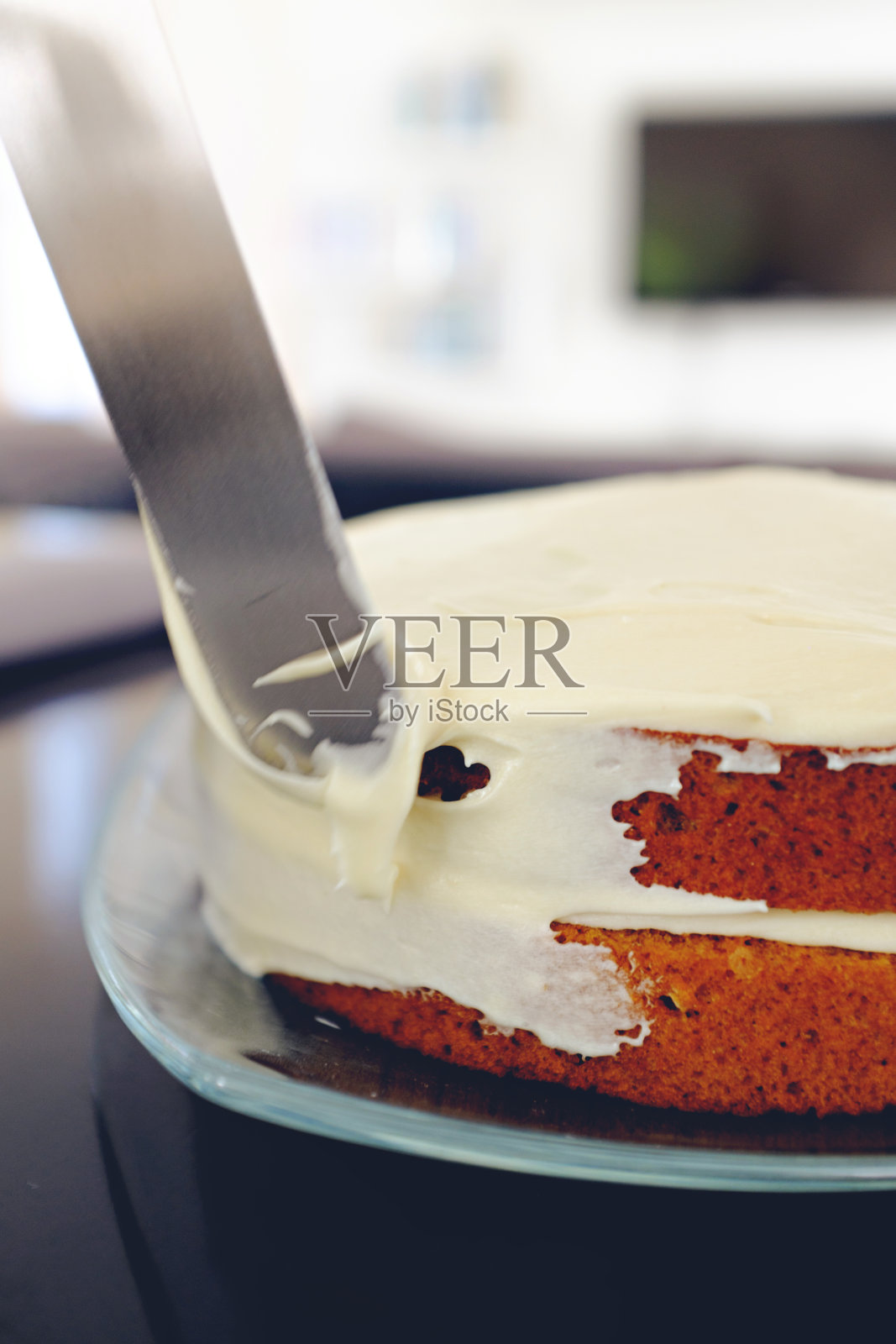 给胡萝卜蛋糕上糖霜的行为照片摄影图片