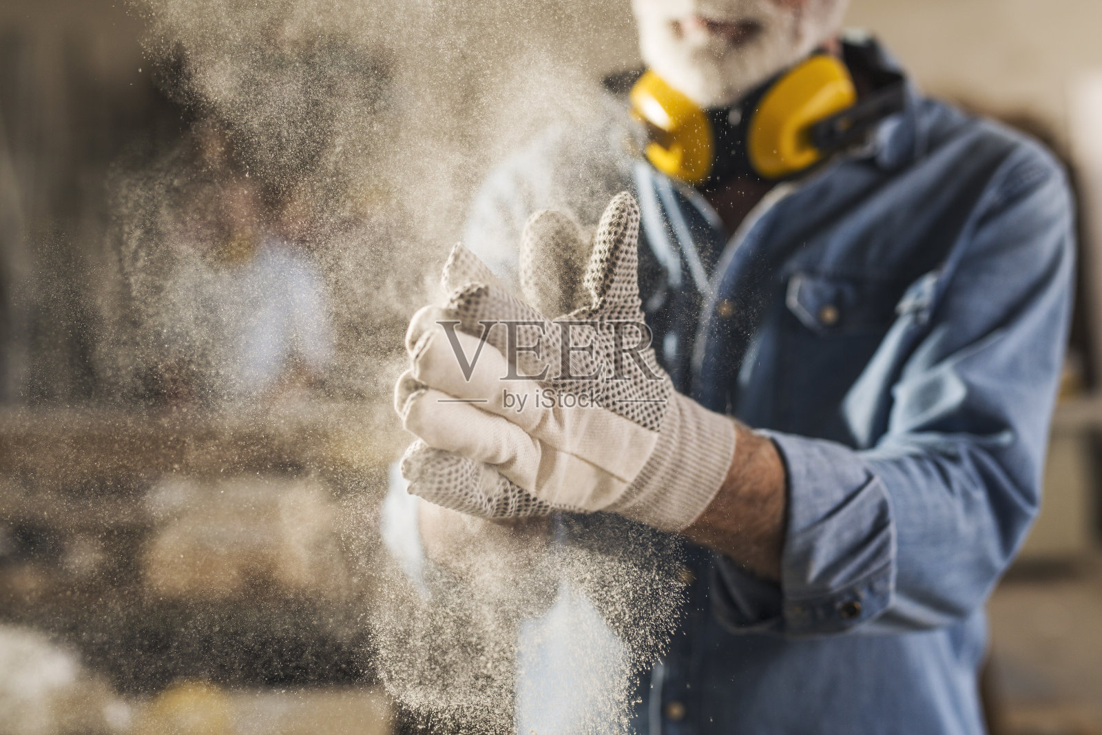 工人正在擦他的工作手套来清洁它们照片摄影图片